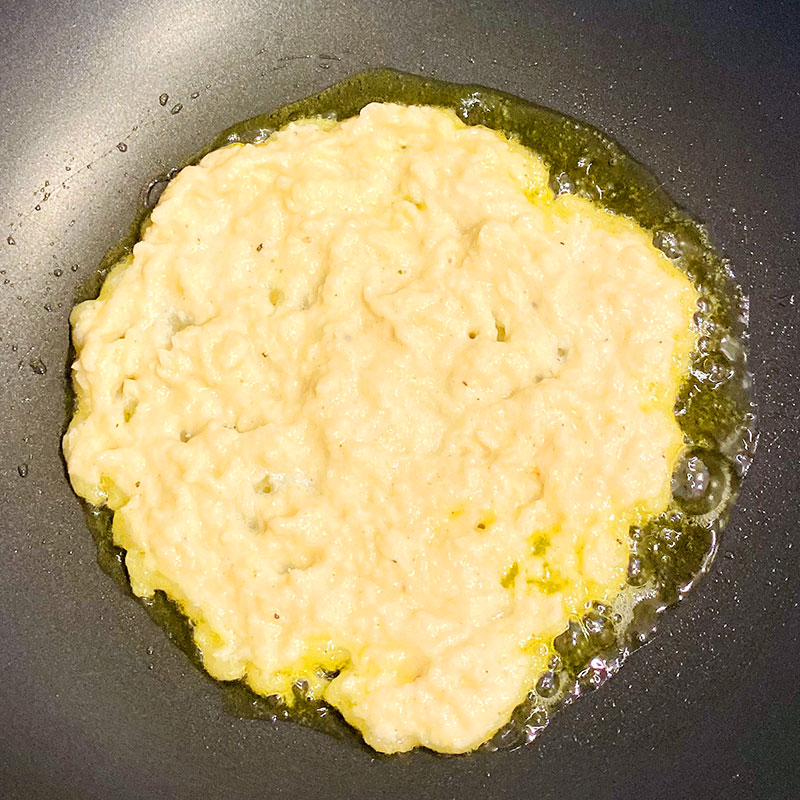 Drop about 2-3 tablespoons of potato mix onto the heated olive oil. And flatten it to make a pancake.