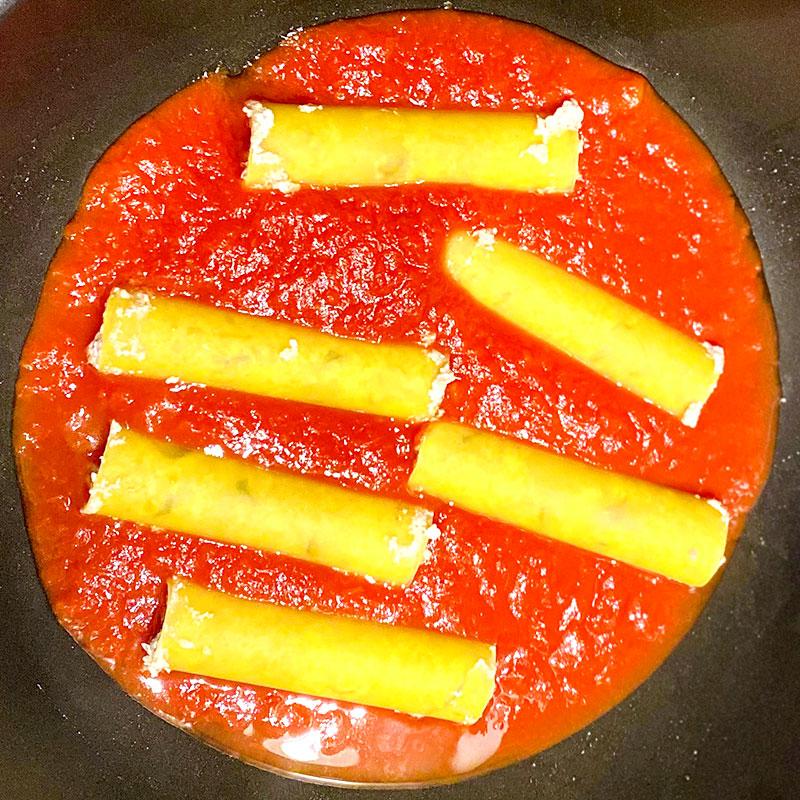 詰めたカネロニパスタとカットトマトをフライパンに入れ、時々カネロニパスタを回しながら約15分煮る